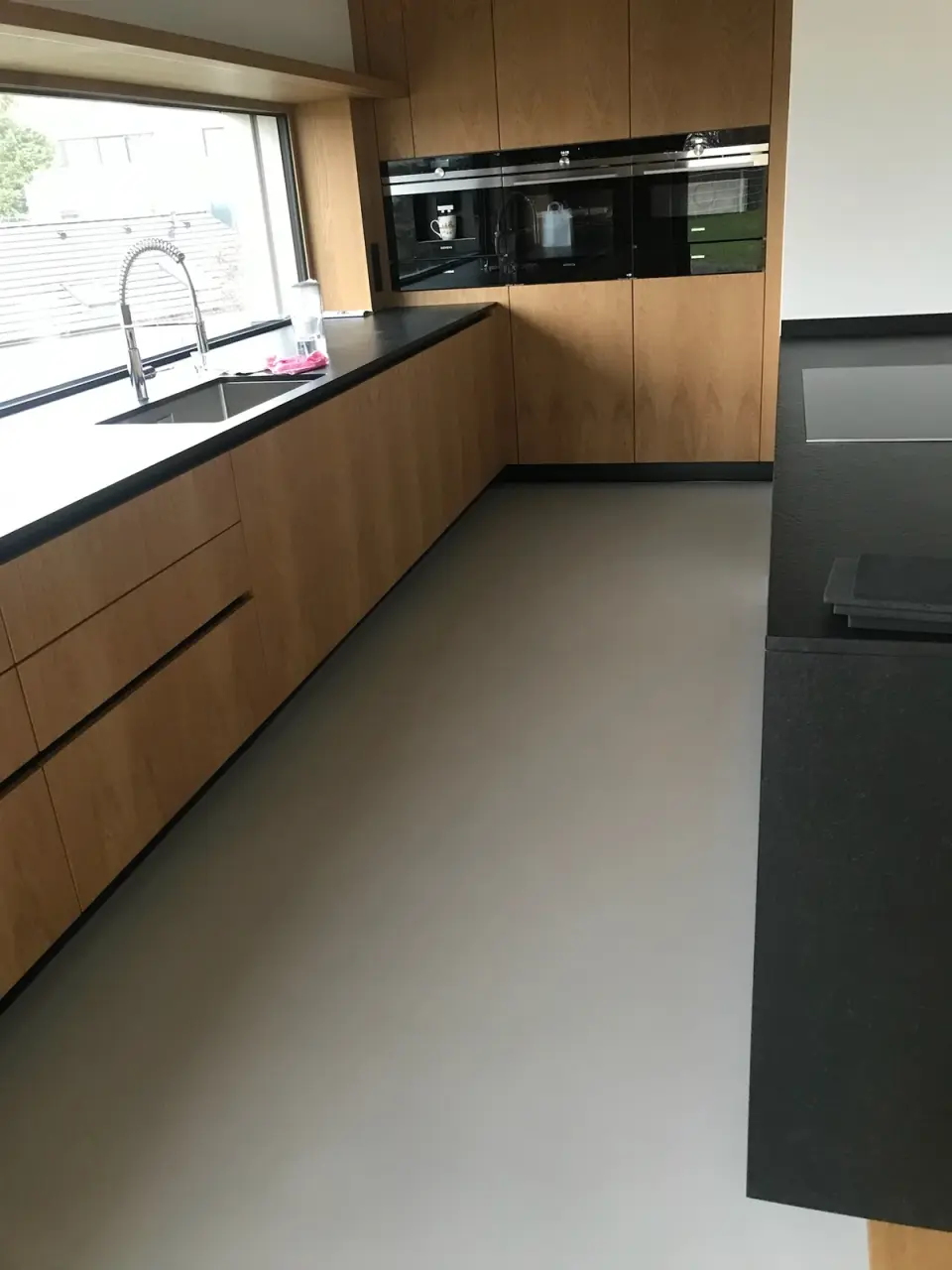 Kuchyně se šedou bezespárou stěrkovou podlahou