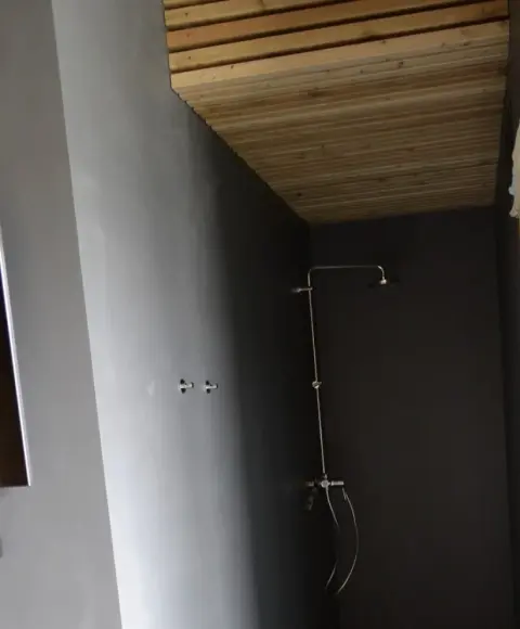 Sprchový kout s tmavě šedou stěrkou na stěnách a podlaze