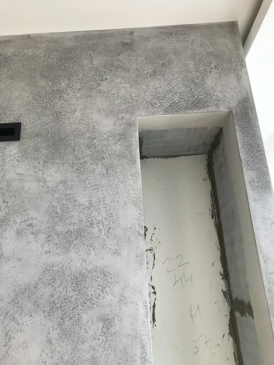 Postup: betonová stěrka na krbu, boční výklenek ještě čeká na dokončení