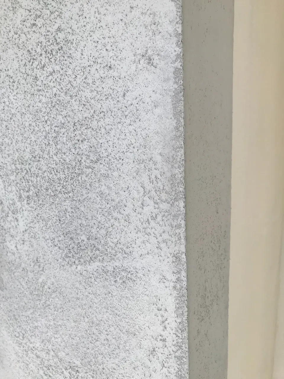 Detail skvrnité struktury betonové stěrky na nároží