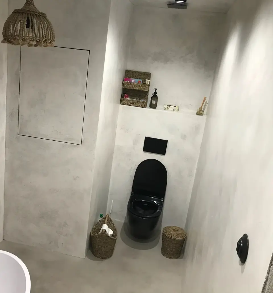 Nika se závěsným WC a revizní dvířka ve světle šedé betonové stěrce