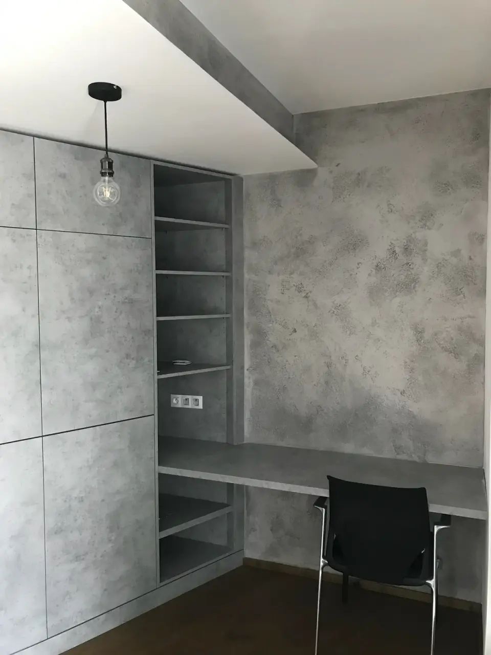 Pracovní kout se stěnami ve světle šedé betonové stěrce