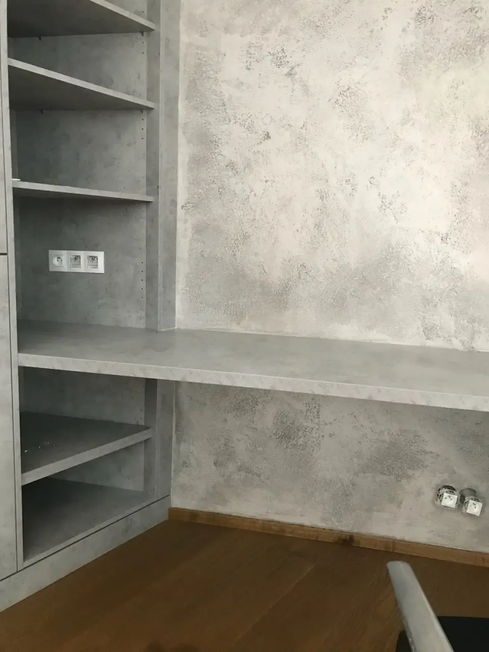 Police a pracovní deska u stěny v betonové stěrce