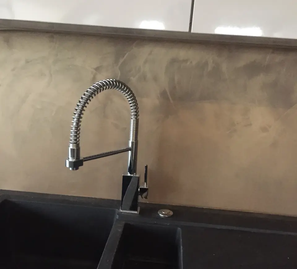 Kuchyňská zástěna v béžové metalické stěrce za černým dřezem