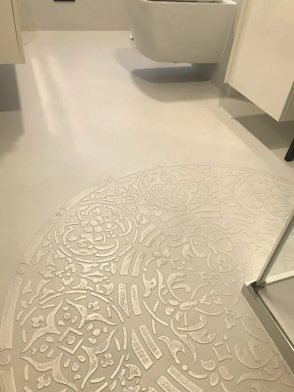 Reliéfní mandala ze stěrky na podlaze koupelny