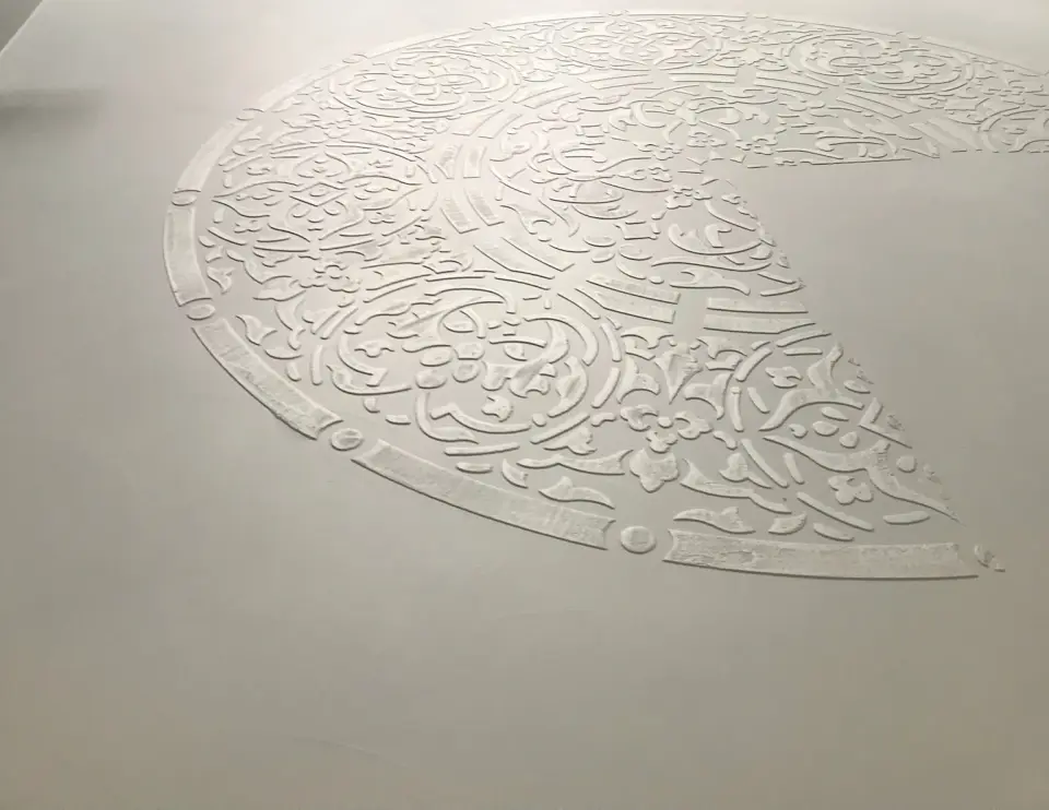 Velká reliéfní mandala na šedé stěrkové podlaze