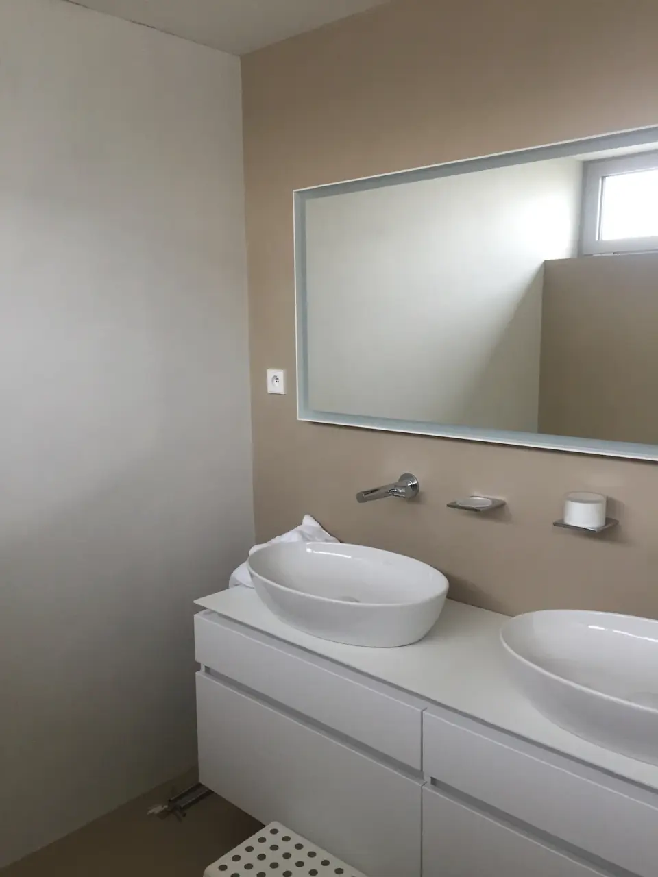 Umyvadlo na skříňce a stěna v béžové stěrce
