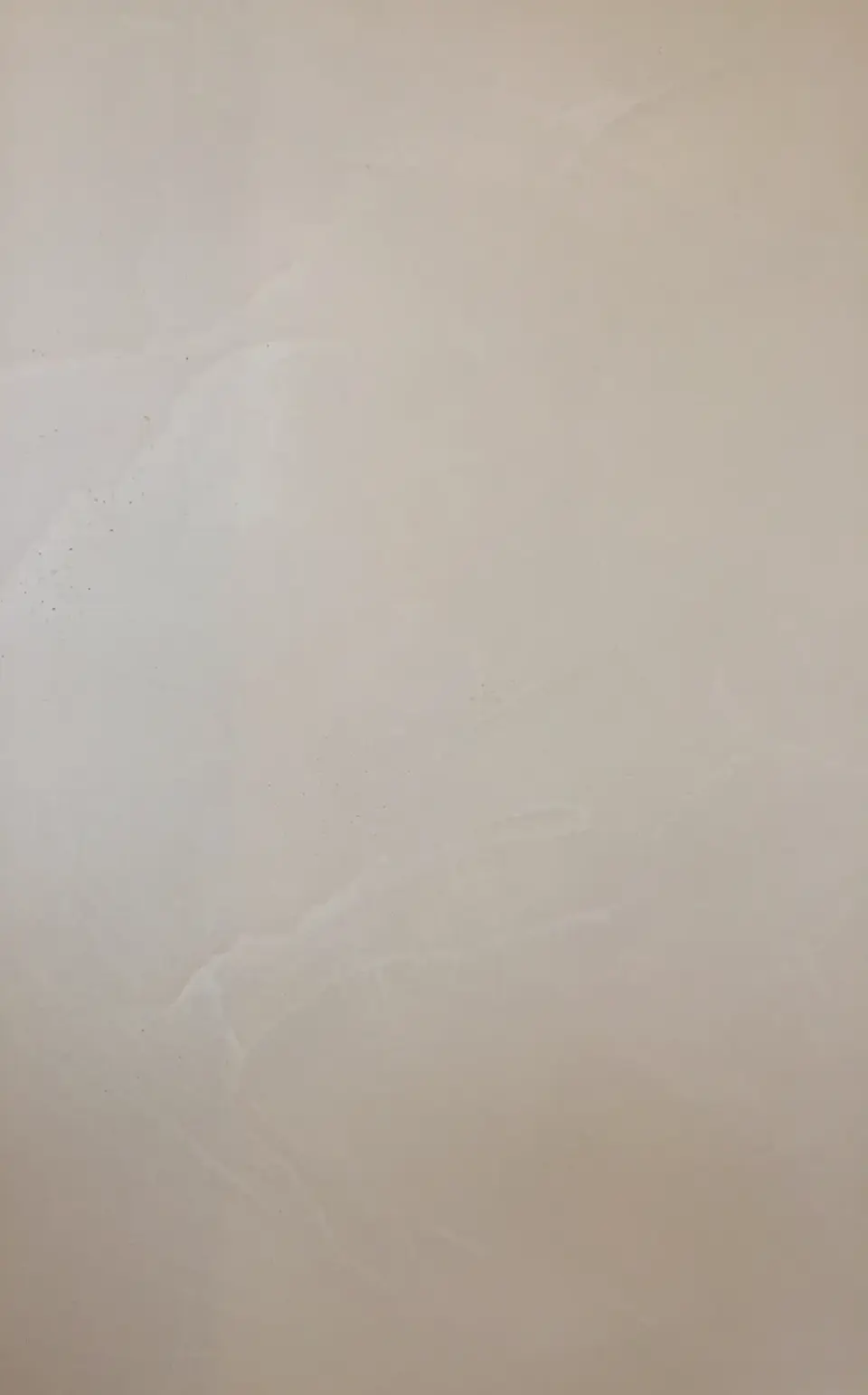 Detail béžové stěrky s jemnou kresbou hladítka na stěně koupelny