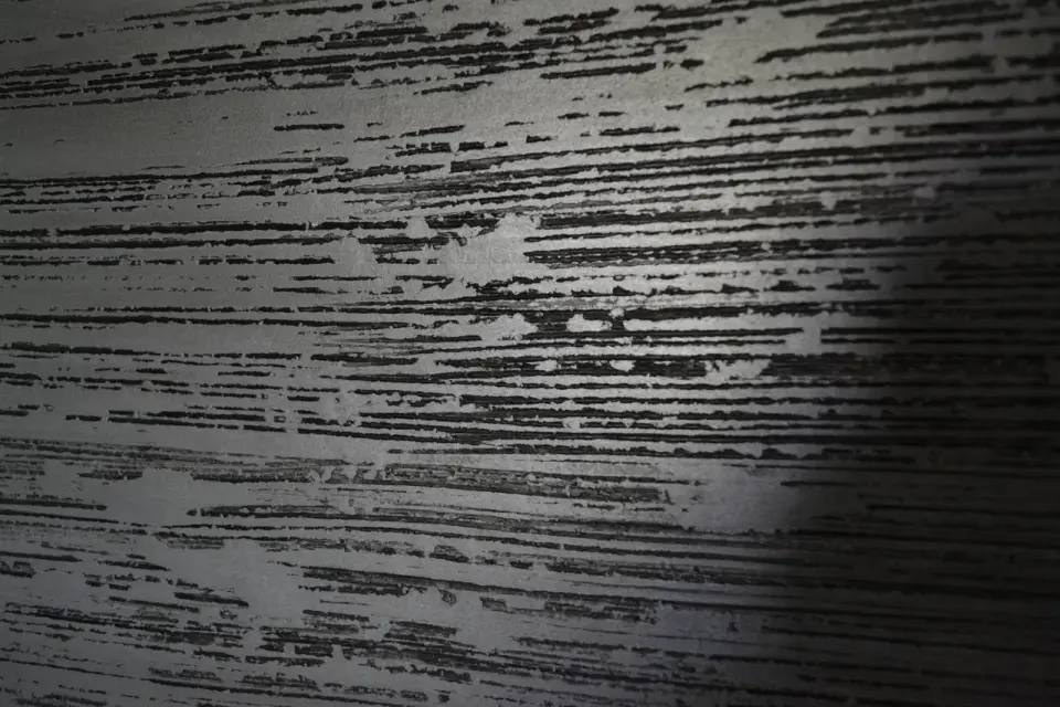 Detail černých a stříbrných pruhů v rýhované stěrce