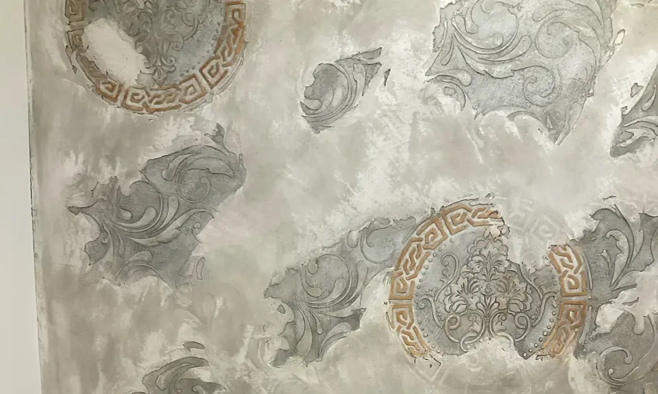 Šedé reliéfní ornamenty a okrový meandr ve světlé stěrce