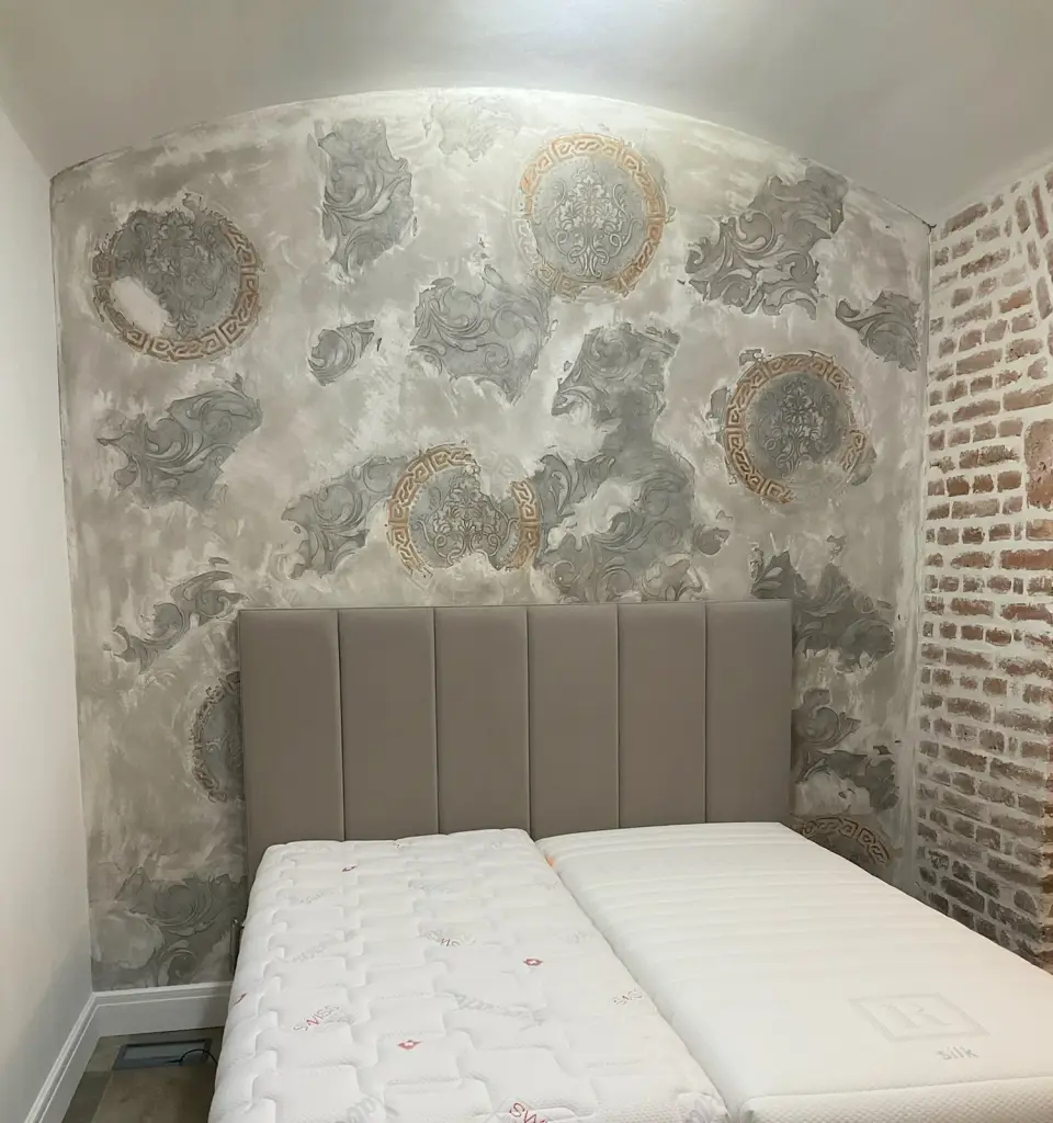 Světlá štuková stěrka s reliéfními ornamenty na klenuté stěně