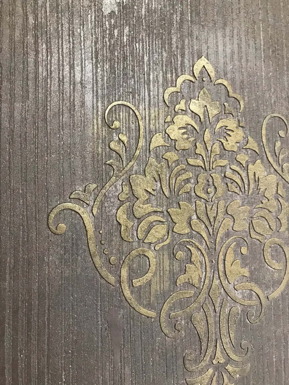 Detail zlatého damaškového ornamentu na rýhované stěrce