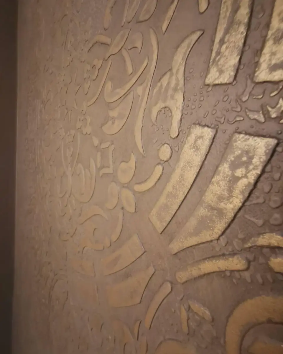 Detail plastické mandaly se zlatou patinou na stěrce