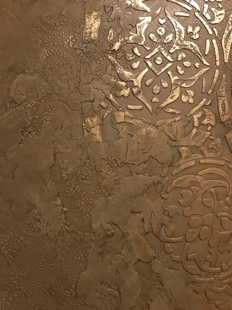 Detail ornamentů se zlatou patinou na hnědé stěrce