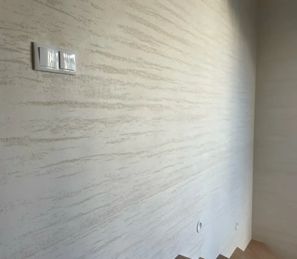 Stěna u schodiště v krémové stěrce v imitaci travertinu