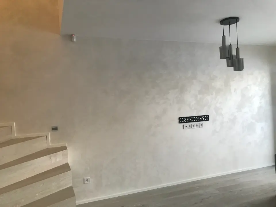 Stěna u schodiště ve světlé perleťové mramorované stěrce