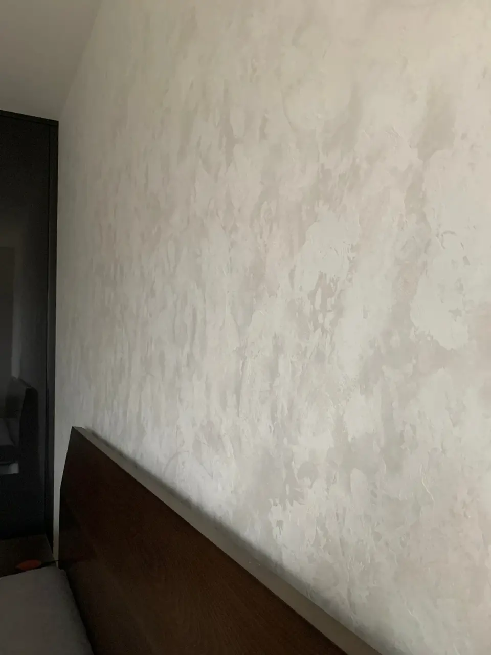 Perleťová stěrka nad čalouněným čelem postele v ložnici