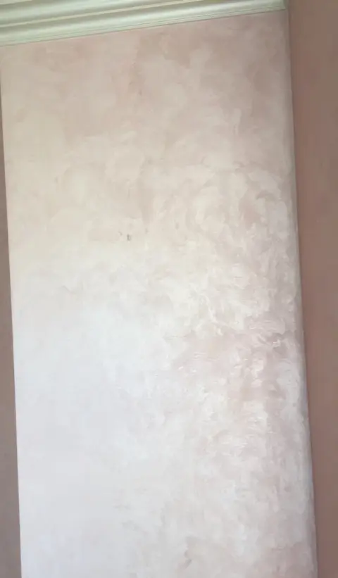 Nároží stěny v růžové štukové stěrce pod bílou štukovou lištou
