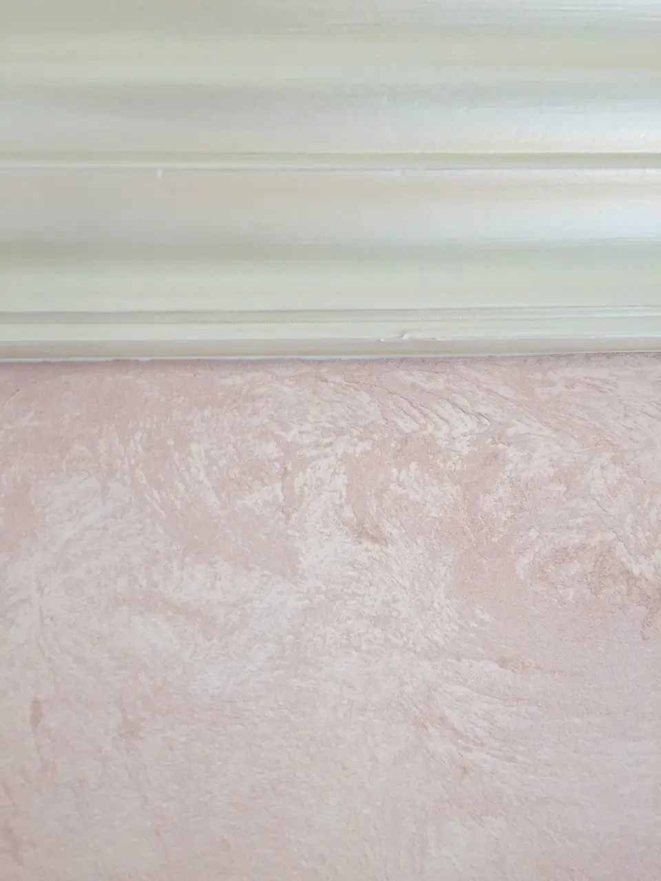 Růžová stěrka s tahy hladítka těsně pod štukovou lištou