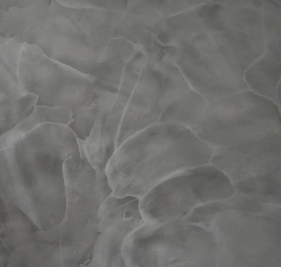 Detail tahů hladítka v šedé mramorované stěrce