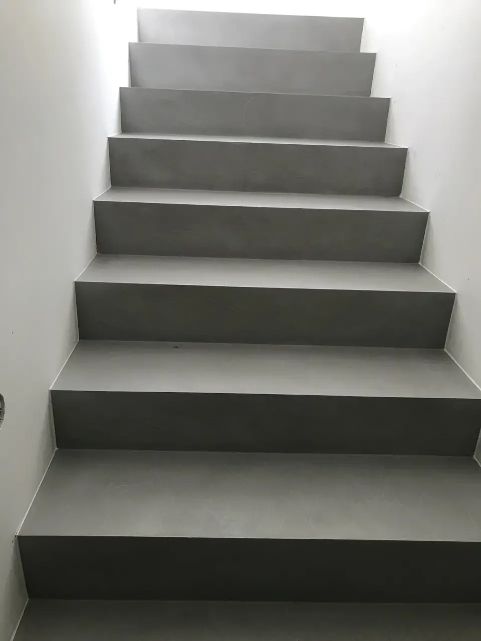 Schodiště se stupni v šedé hladké stěrce