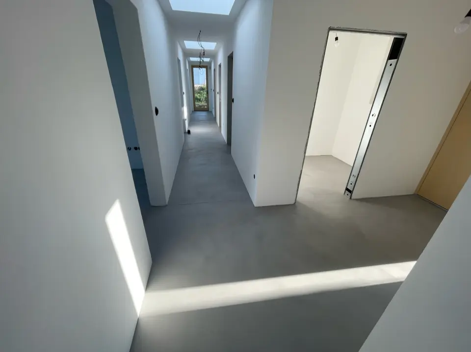 Chodba se šedou bezespárou podlahou ze stěrky