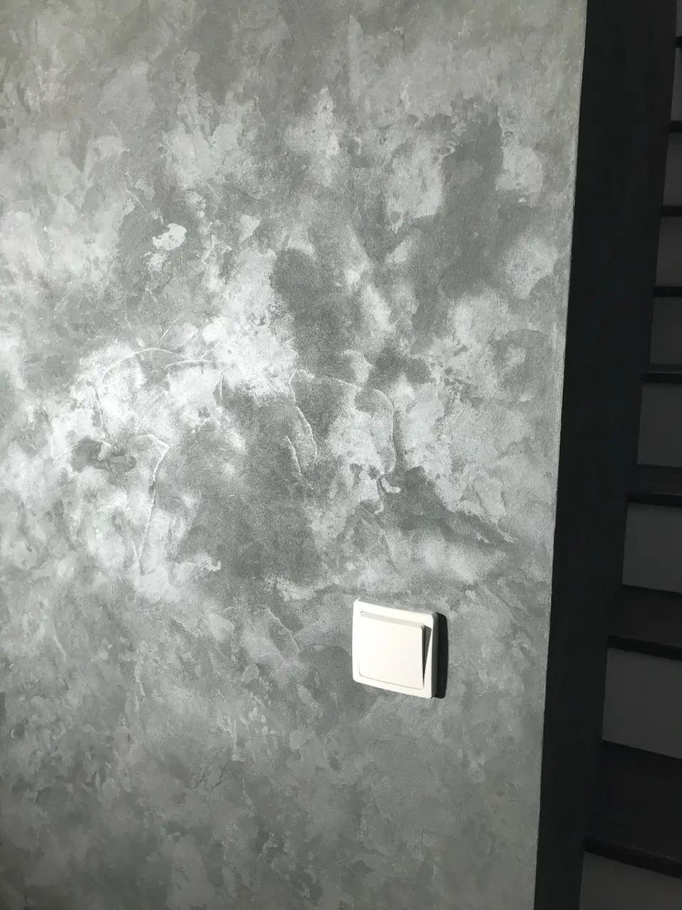Stěna u schodiště v šedé oblačné stěrce
