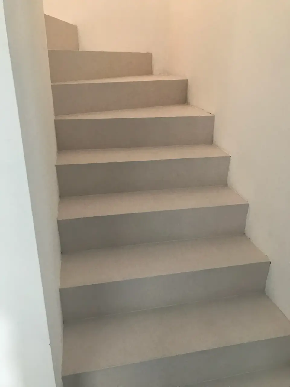 Schodiště s nášlapy i podstupnicemi ve světlé stěrce