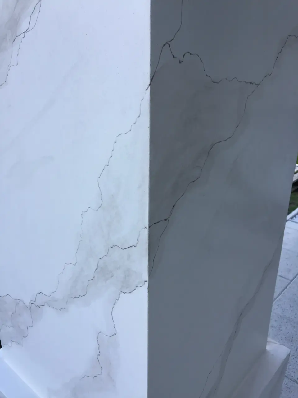 Detail nároží pilíře s žilkami v bílé mramorové stěrce