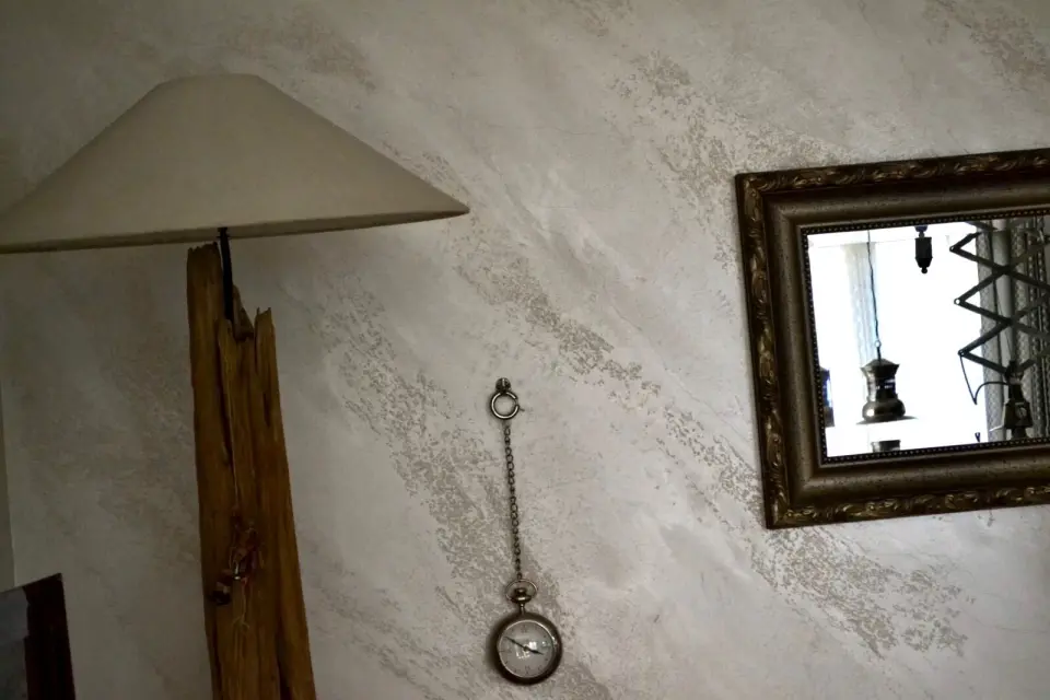 Mramorová stěrka s reliéfem za lampou z kmene a zrcadlem