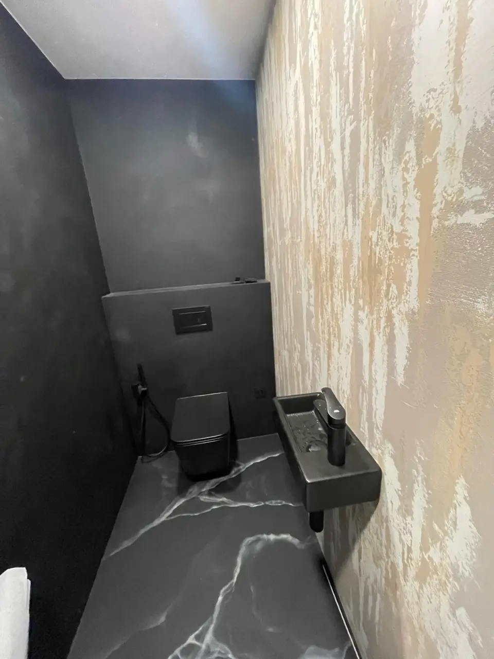 WC s černou mramorovou stěrkou na podlaze