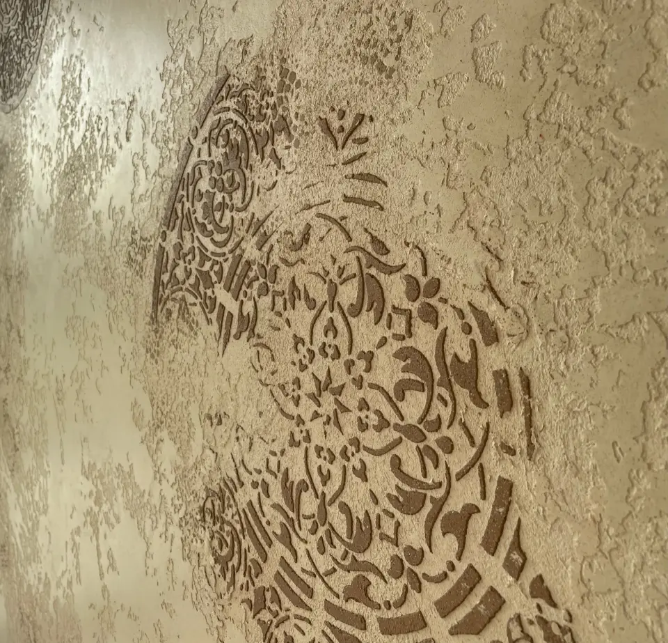 Velký hnědý ornament na béžové plastické stěrce