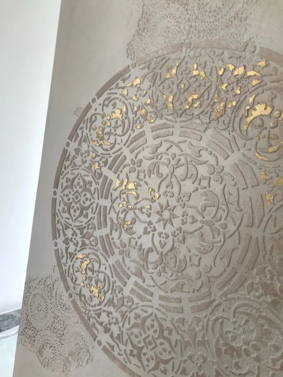 Detail mandaly se zlatými plátky ve stěrce