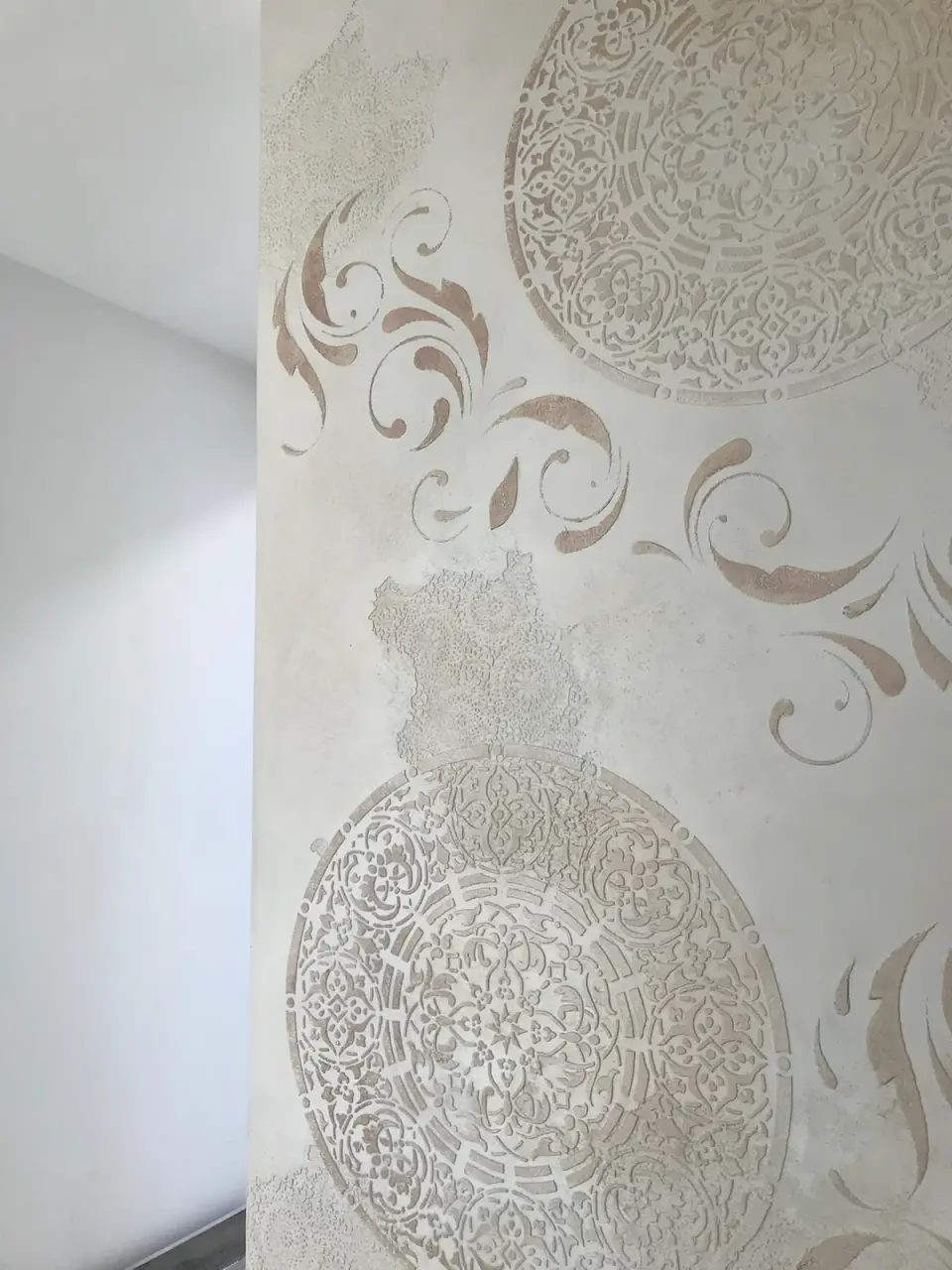Dvě reliéfní mandaly a florální ornamenty na pilíři ve stěrce