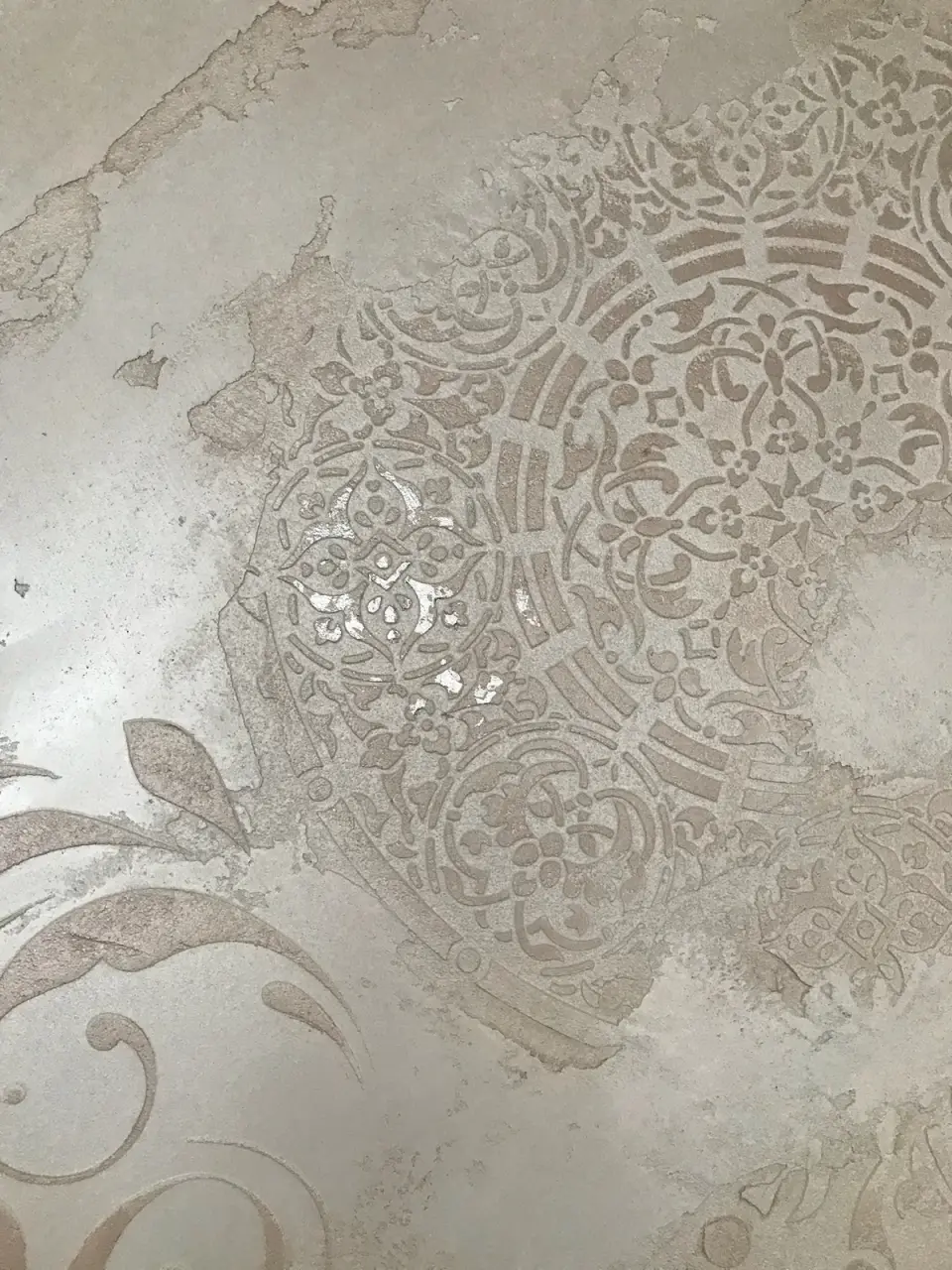 Detail mandaly se zlatými plátky v reliéfu stěrky