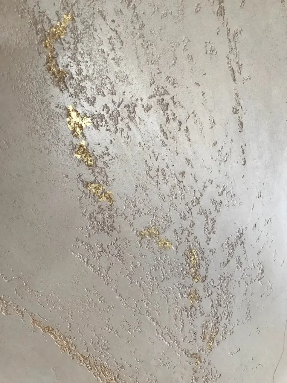 Detail zlatých plátků v mramorové stěrce