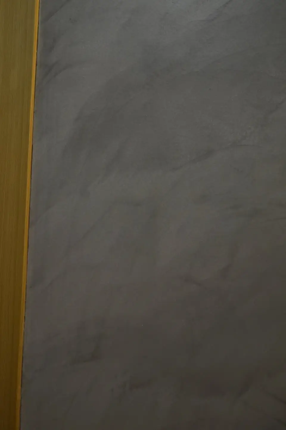 Detail tmavě šedé stěrky u dřevěné zárubně