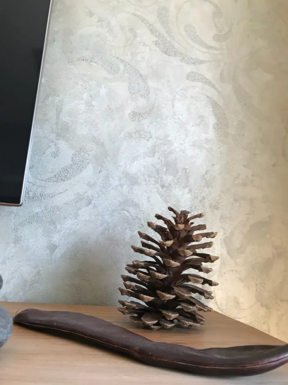 Detail stěrky s ornamentem nad dřevěnou komodou