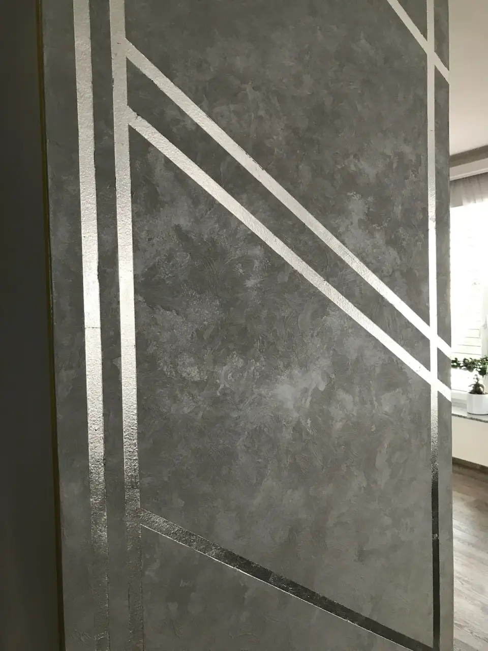 Detail šedé stěrky se stříbrnými pruhy