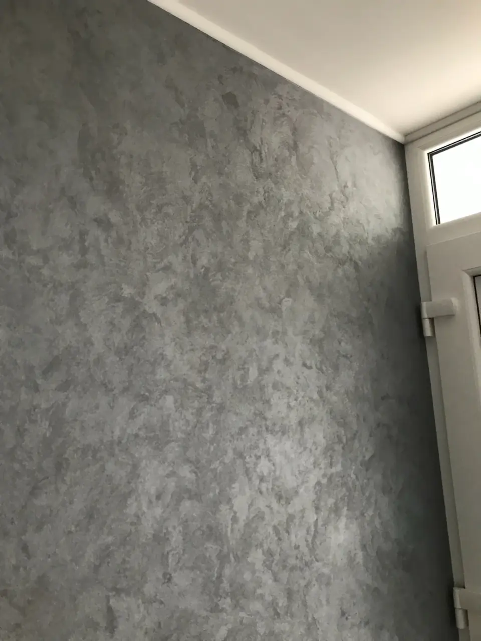Stěna u balkonových dveří v šedé skvrnité stěrce