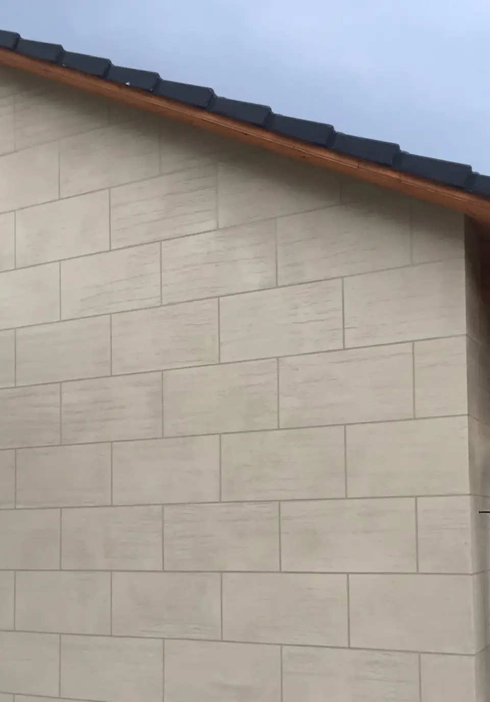 Štítová zeď s kvádry ze stěrky v imitaci pískovce pod okapem