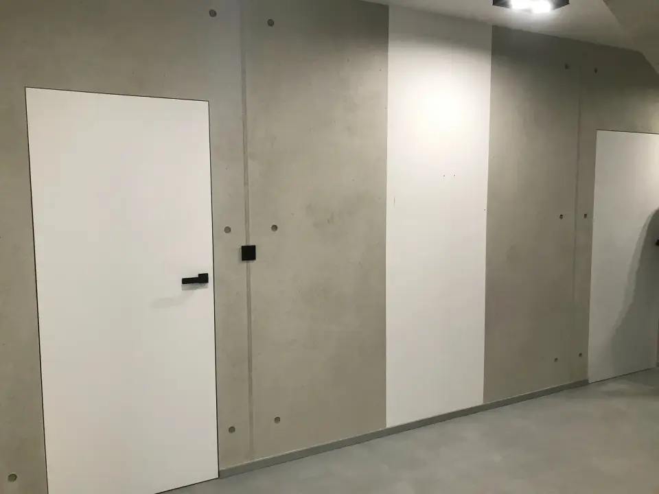 Stěna ve stěrce v imitaci pohledového betonu se skrytými dveřmi