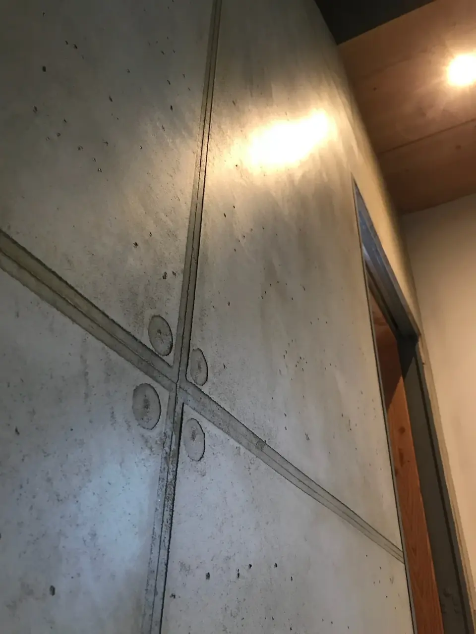 Vysoká stěna u dveří ve stěrce v imitaci pohledového betonu