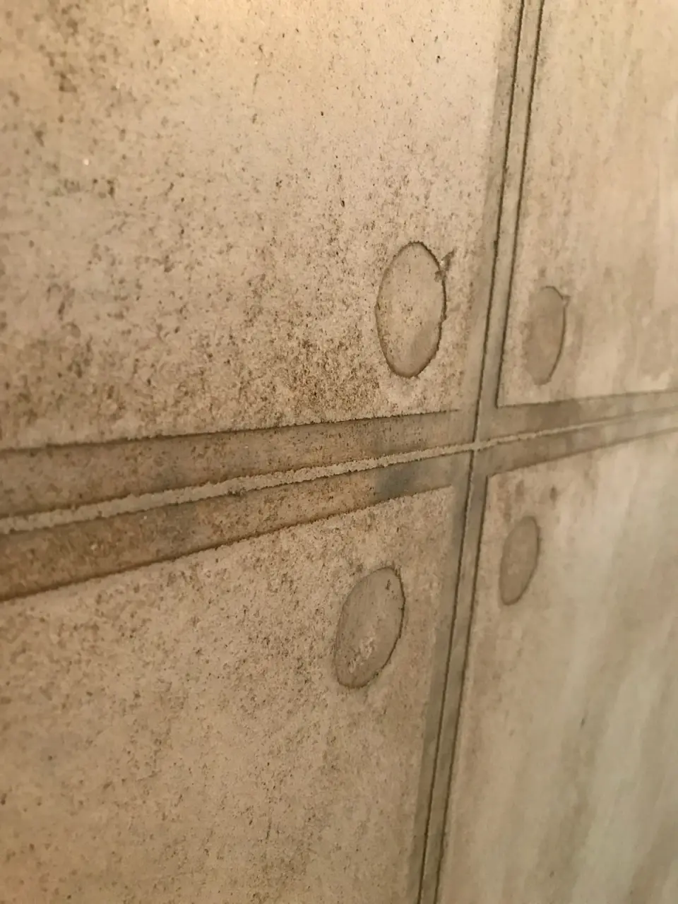 Detail spár a otisků kotev v imitaci betonu ze stěrky