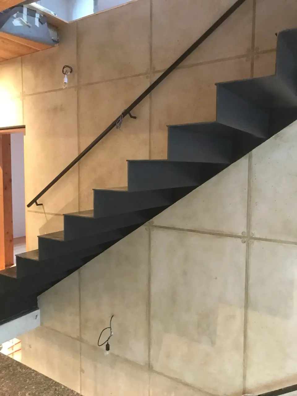 Postup: stěrka v imitaci betonu pod schodištěm s visícími kabely