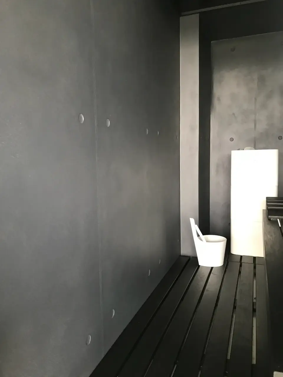 Interiér sauny s tmavou stěrkou v imitaci pohledového betonu