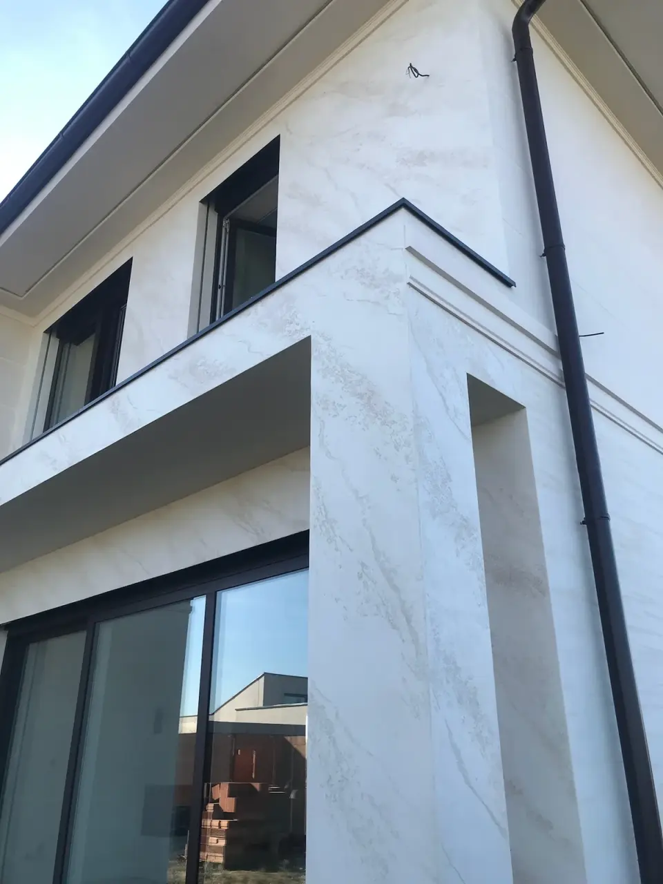 Nároží s balkonem ve stěrce s mramorovými žilkami