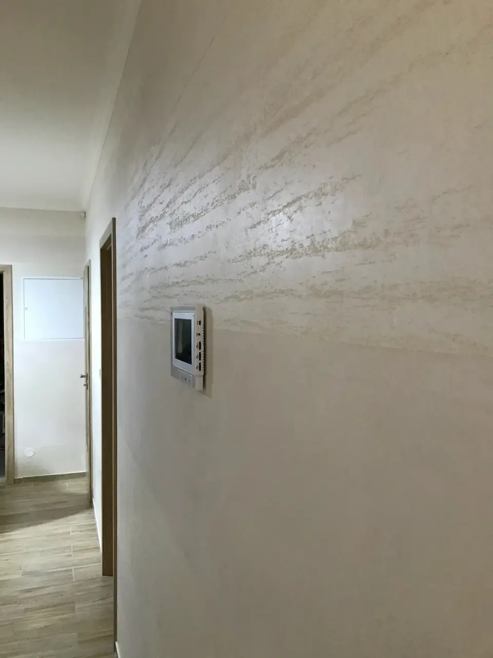 Dlouhá chodba se stěrkou v imitaci travertinu