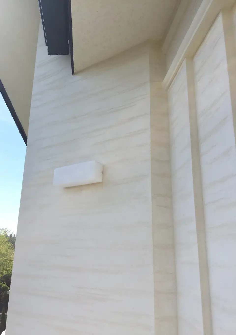 Nároží fasády s lizénami ve stěrce v imitaci travertinu zespodu