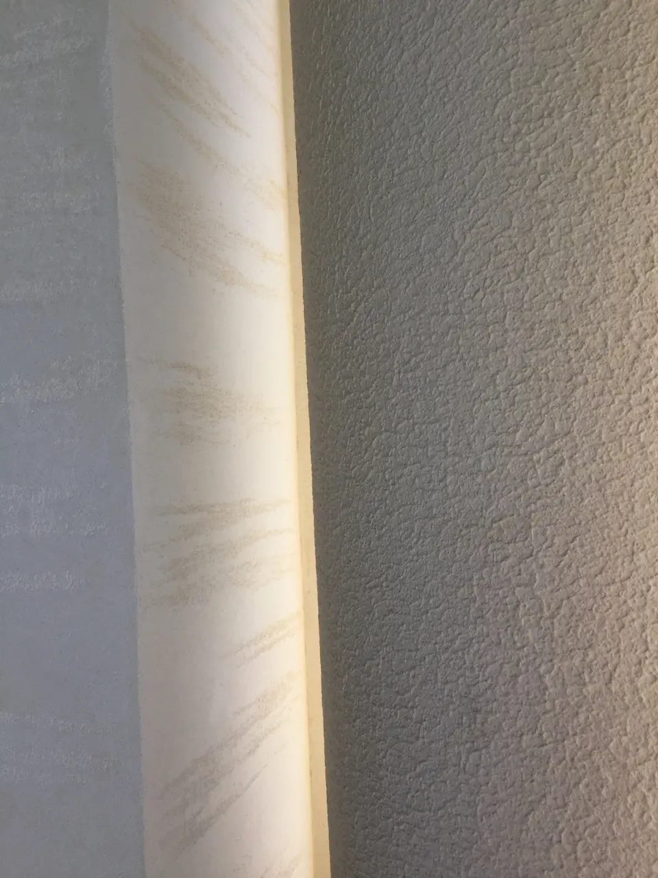 Detail rohu lizény ve stěrce v imitaci travertinu na fasádě